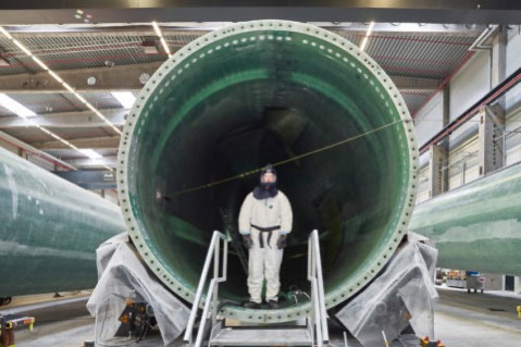 A worker assembling a wind turbine blade, Denmark.